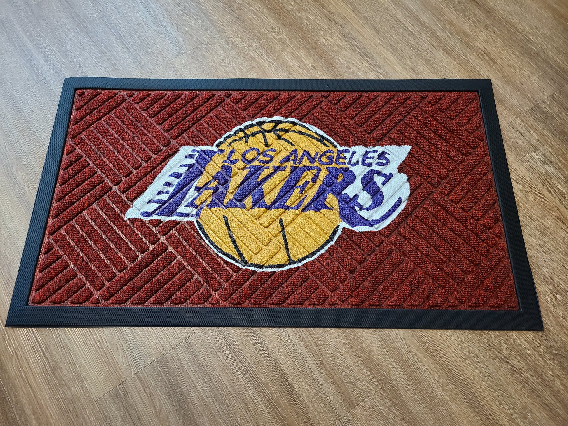 Los Angeles Lakers doormat on red floor mat.