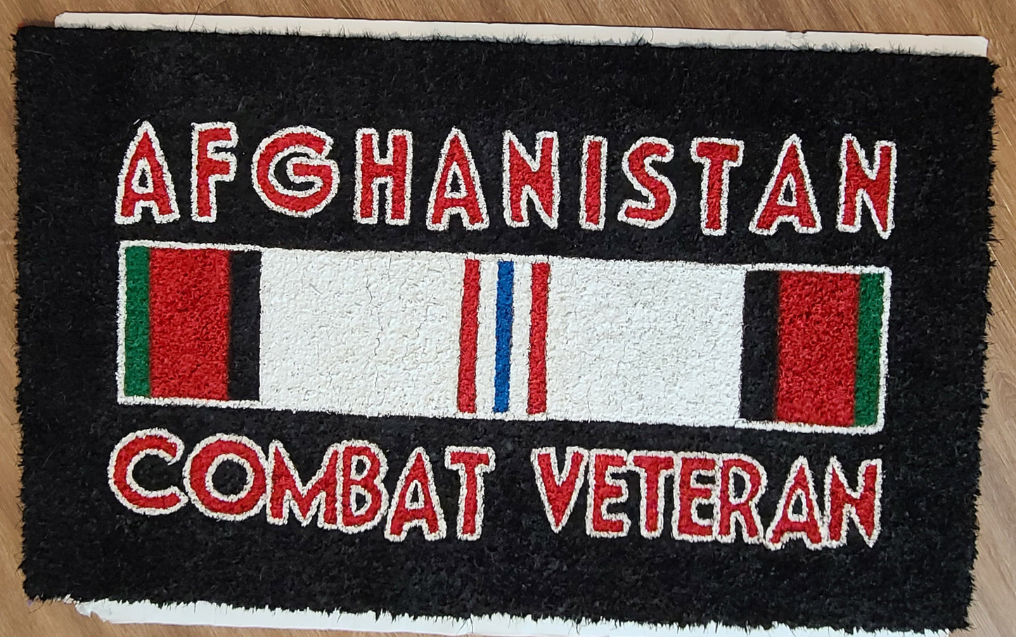 Doormat with 'Combat Veteran Afghanistan' text and a flag design on a black background.